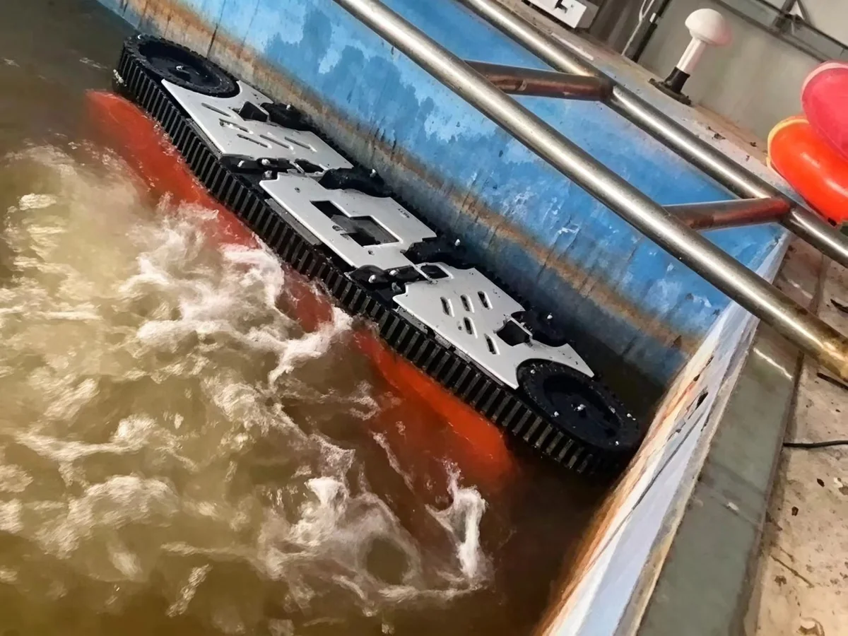 Q180 hull cleaning unit held by thrusters on a concrete wall in a test pool